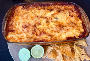 High-protein taco tortilla bake layered with seasoned beef, beans, cottage cheese and melted cheese, sliced in a baking dish