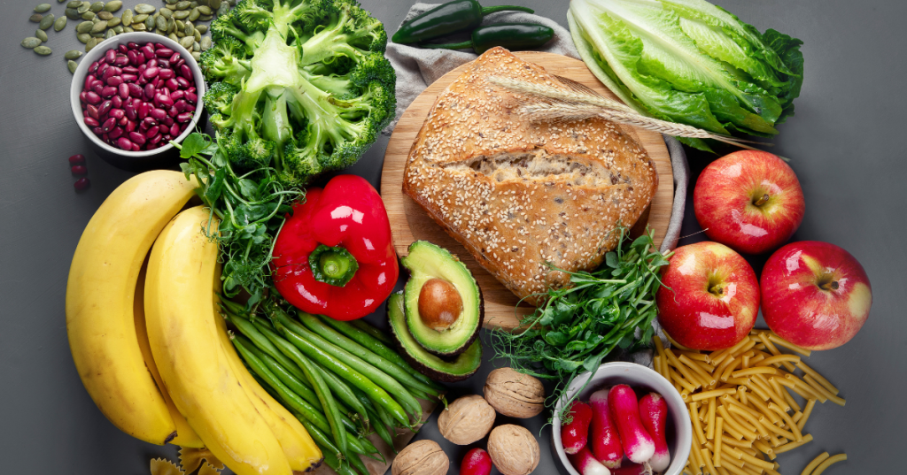 Assorted high-fiber vegetables arranged together, including broccoli, carrots, kale, leafy greens, bell peppers, and sweet potatoes, highlighting a colorful selection of plant-based, fiber-rich foods.